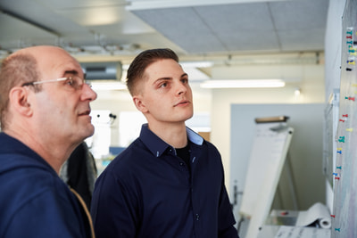 Männer studieren Anschlag an der Wand Männer studieren Anschlag an der Wand